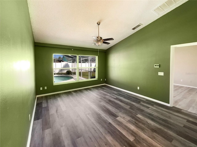 empty room with baseboards, visible vents, lofted ceiling, ceiling fan, and wood finished floors