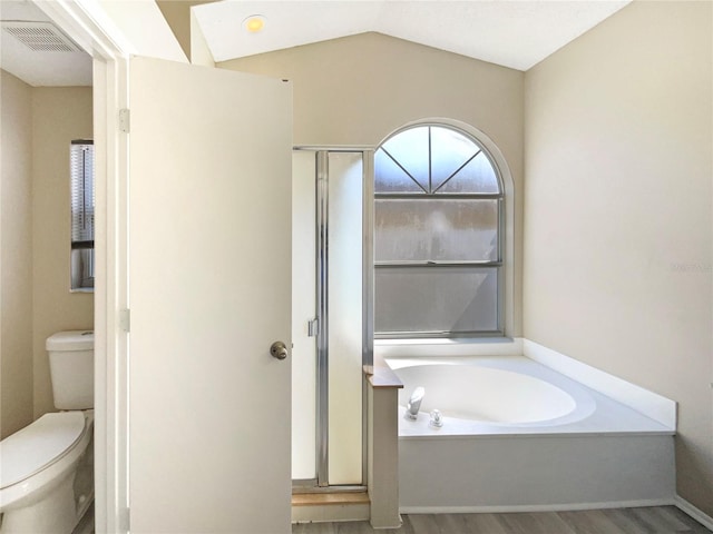 full bathroom with a garden tub, toilet, wood finished floors, visible vents, and vaulted ceiling