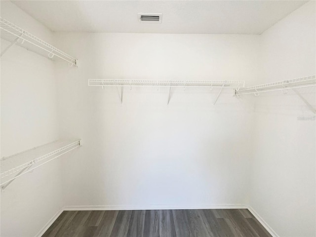 spacious closet with dark wood-style flooring and visible vents