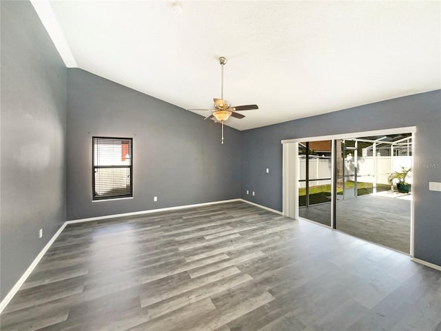 spare room featuring ceiling fan, high vaulted ceiling, wood finished floors, and baseboards