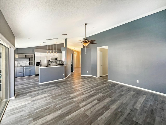 unfurnished living room featuring baseboards, a ceiling fan, lofted ceiling, dark wood-style floors, and a textured ceiling