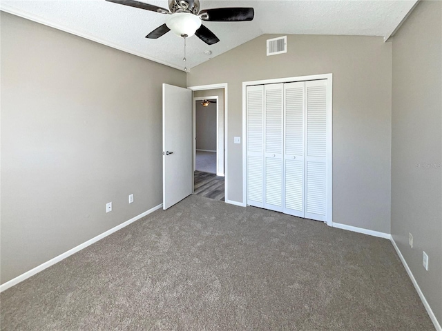 unfurnished bedroom featuring carpet flooring, visible vents, baseboards, vaulted ceiling, and a closet