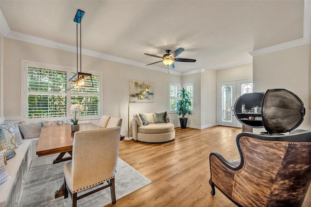 interior space with light wood-style flooring, baseboards, crown molding, and a ceiling fan