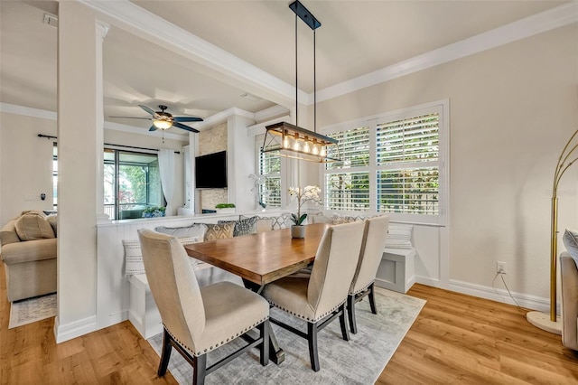 dining area with baseboards, ceiling fan, crown molding, and light wood finished floors