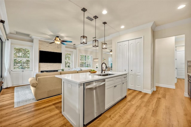 kitchen featuring visible vents, a sink, stainless steel dishwasher, open floor plan, and light countertops