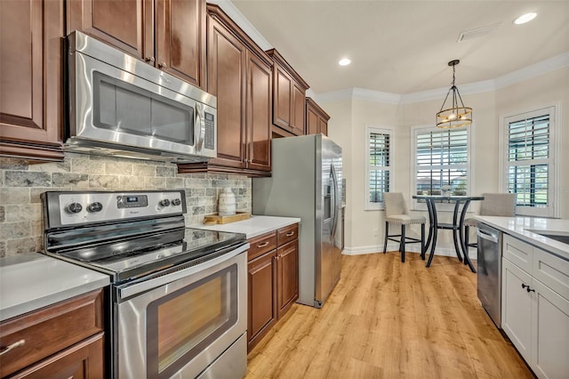 kitchen featuring light countertops, tasteful backsplash, appliances with stainless steel finishes, and ornamental molding