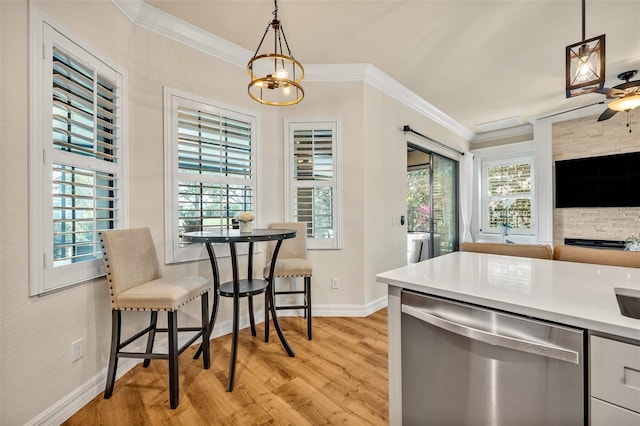 kitchen featuring light wood-style flooring, ornamental molding, dishwasher, decorative light fixtures, and open floor plan