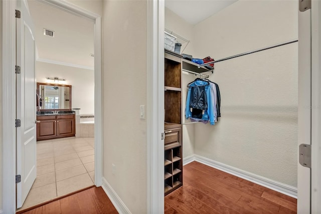 walk in closet with visible vents and light wood-type flooring