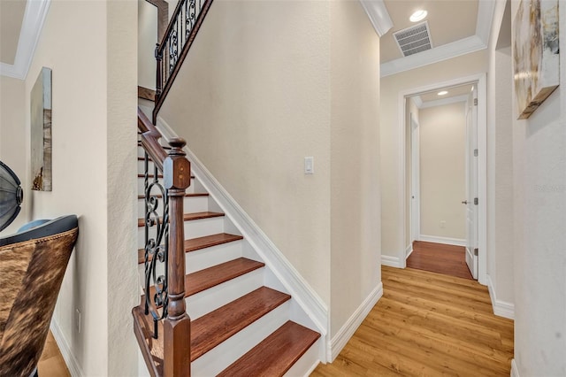 staircase featuring visible vents, wood finished floors, recessed lighting, crown molding, and baseboards