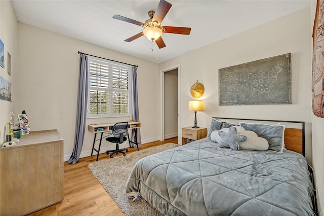 bedroom with a ceiling fan, baseboards, and wood finished floors