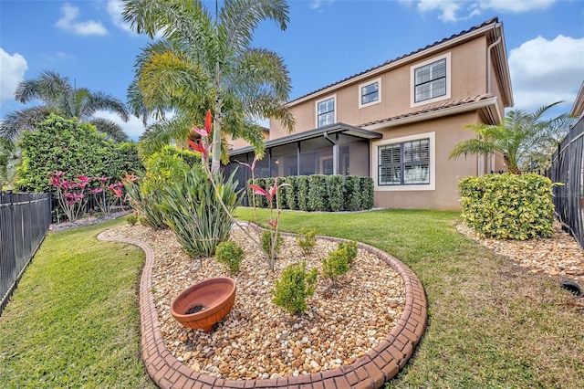 view of yard featuring a fire pit, a fenced backyard, and a sunroom