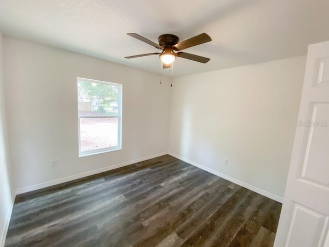 unfurnished room with ceiling fan, baseboards, and dark wood-type flooring