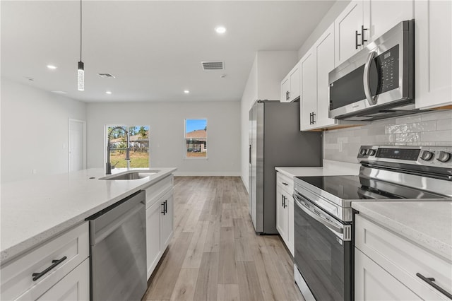 kitchen with white cabinets, visible vents, appliances with stainless steel finishes, and tasteful backsplash