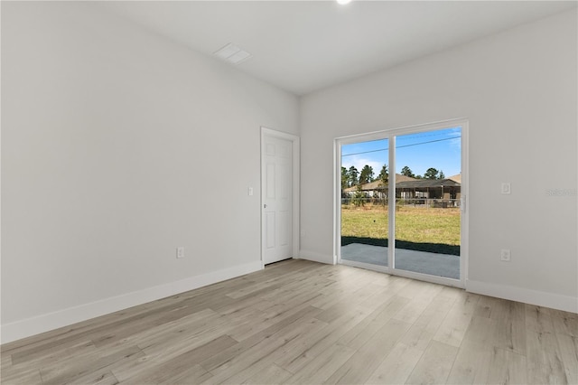 spare room featuring light wood-style floors and baseboards