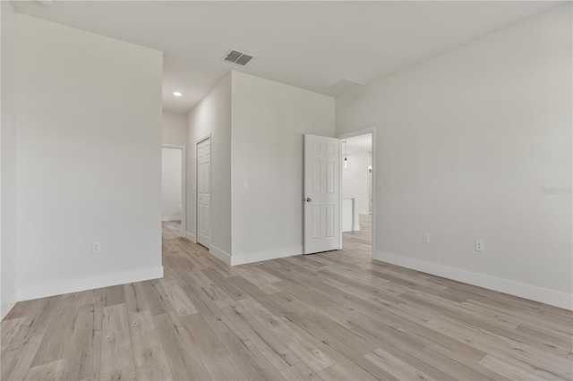 empty room with light wood-type flooring, baseboards, visible vents, and recessed lighting