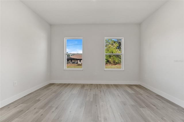 unfurnished room with baseboards and light wood finished floors