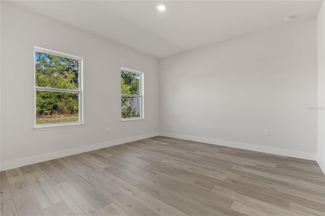 unfurnished room with light wood finished floors and baseboards