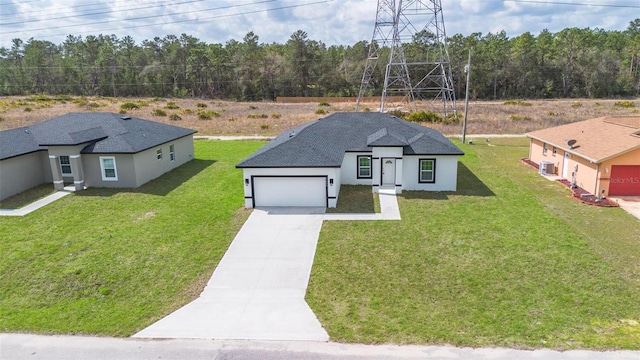 view of front of property with a front yard, driveway, an attached garage, and stucco siding