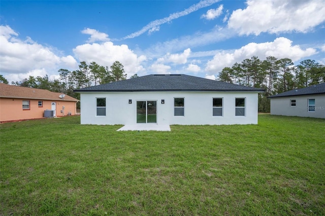 back of house with central air condition unit and a yard