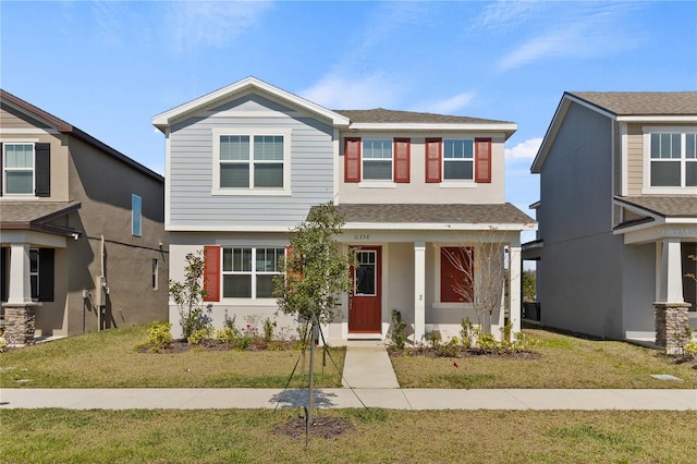 view of front facade featuring stucco siding, a shingled roof, and a front lawn