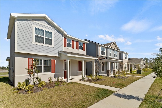 view of property with a residential view, stucco siding, and a front yard