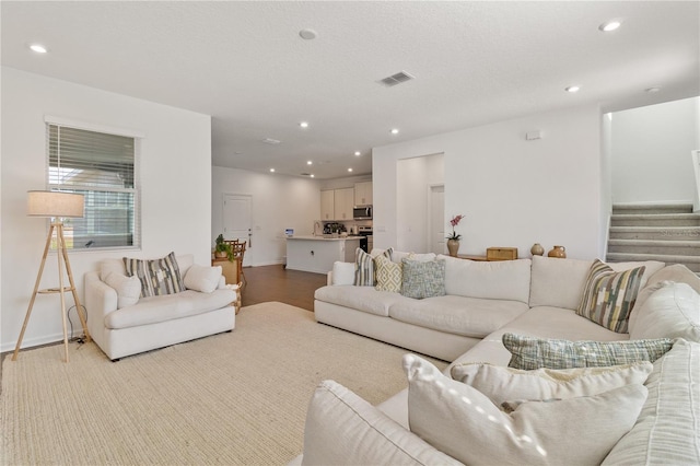 living room featuring stairway, recessed lighting, visible vents, and baseboards