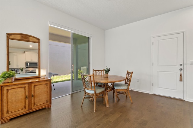 dining room featuring dark wood-style floors, arched walkways, and baseboards