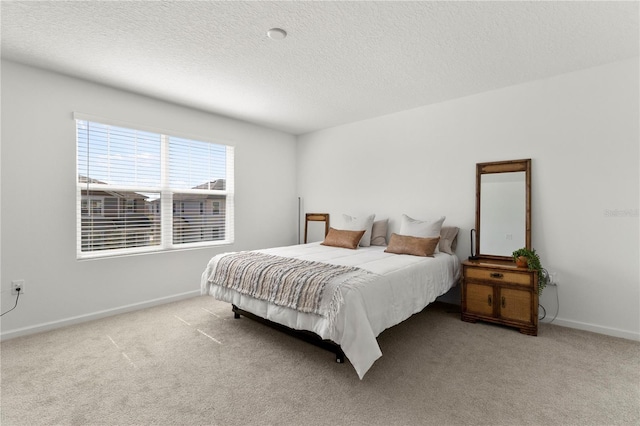 carpeted bedroom featuring a textured ceiling and baseboards