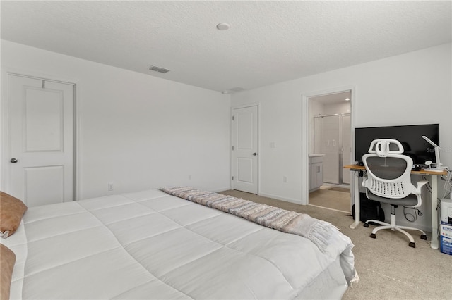 bedroom featuring baseboards, visible vents, a textured ceiling, light colored carpet, and connected bathroom