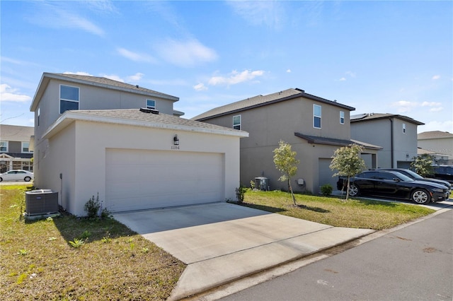 view of front of property featuring stucco siding, driveway, central AC, and an attached garage