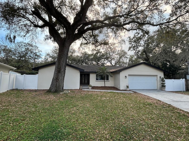 single story home featuring an attached garage, fence, a front lawn, and stucco siding