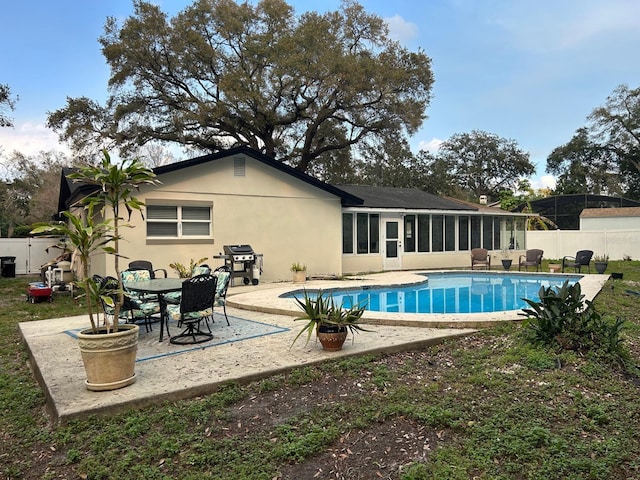 back of property featuring a patio, a fenced backyard, a sunroom, and stucco siding