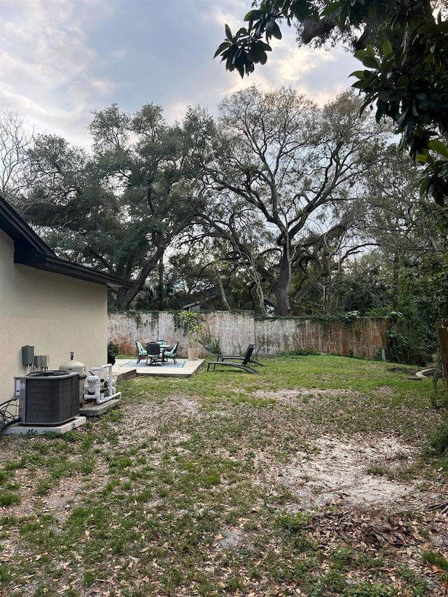 view of yard with fence and central air condition unit