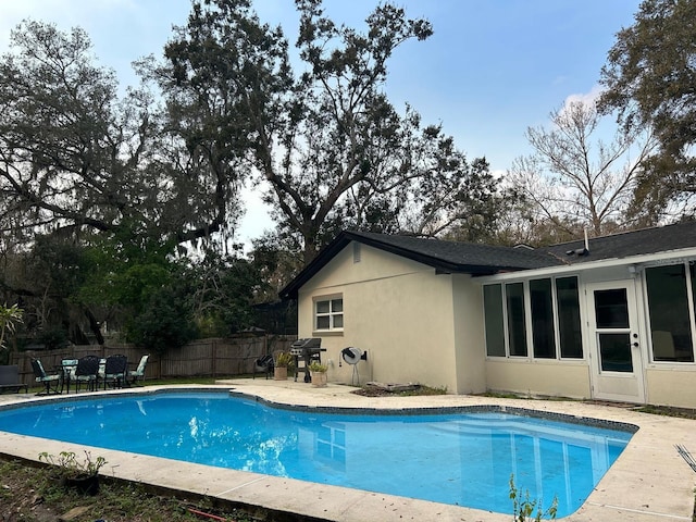 view of swimming pool featuring a fenced in pool, fence, area for grilling, and a patio