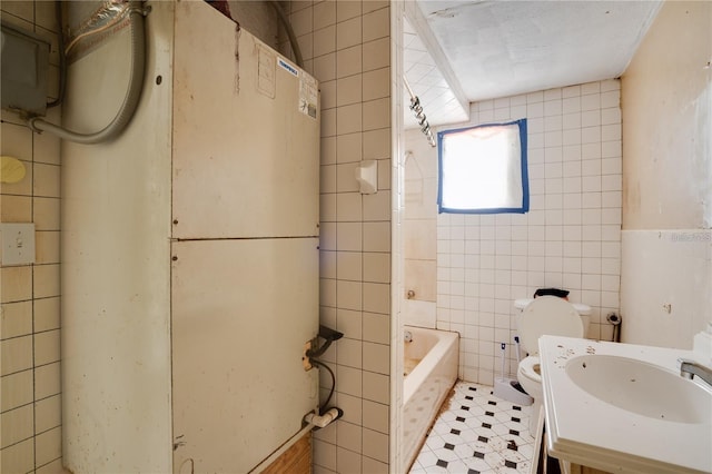 bathroom featuring toilet, a sink, tile walls, and tile patterned floors