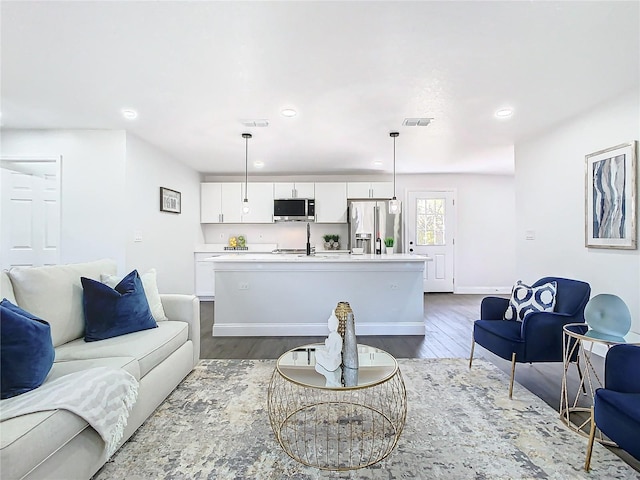 living area with baseboards, dark wood-type flooring, visible vents, and recessed lighting