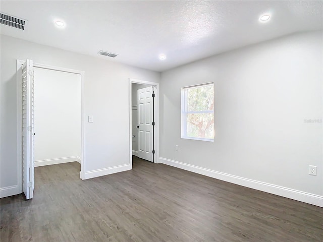 unfurnished bedroom with baseboards, visible vents, wood finished floors, and recessed lighting