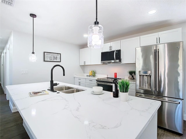 kitchen featuring a kitchen island with sink, a sink, visible vents, white cabinets, and appliances with stainless steel finishes