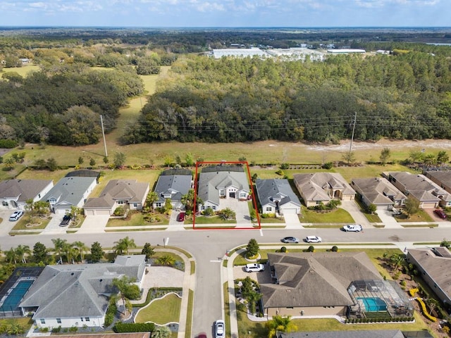 bird's eye view featuring a residential view and a wooded view