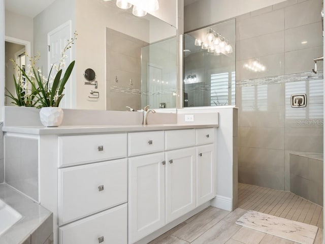 bathroom featuring walk in shower and vanity