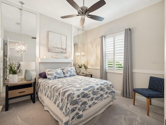 bedroom with ceiling fan with notable chandelier, carpet floors, visible vents, and baseboards