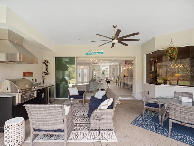 living area with brick floor and ceiling fan with notable chandelier