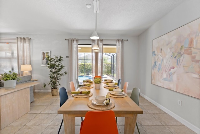 dining space featuring a textured ceiling, light tile patterned floors, and baseboards