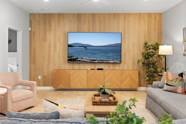 living room featuring wooden walls and light tile patterned floors