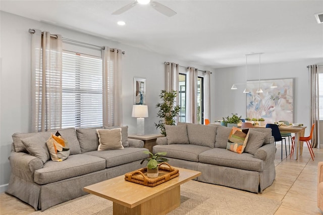 living room featuring light tile patterned floors, visible vents, and a ceiling fan