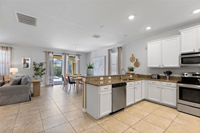 kitchen featuring open floor plan, a peninsula, appliances with stainless steel finishes, and visible vents