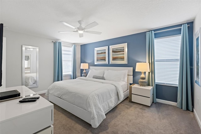 bedroom with light carpet, a textured ceiling, a ceiling fan, and baseboards