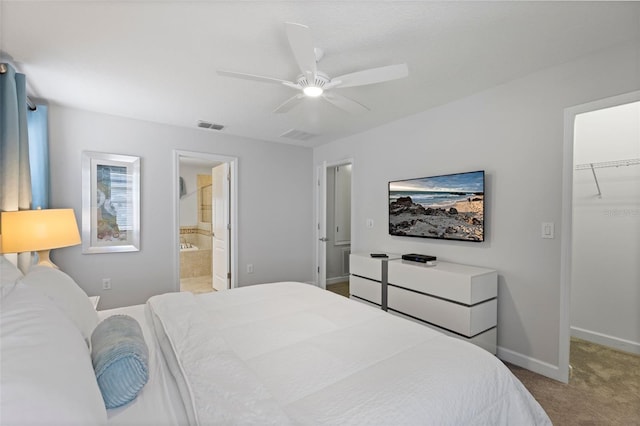 bedroom featuring baseboards, visible vents, light colored carpet, ceiling fan, and a walk in closet