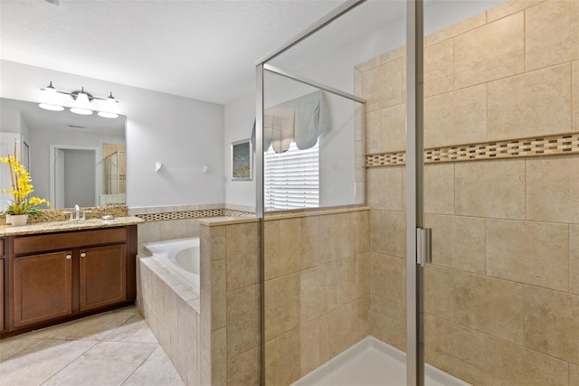 bathroom with a stall shower, tile patterned flooring, a bath, and vanity