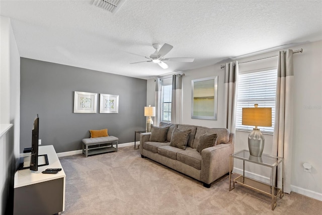 living room with ceiling fan, a textured ceiling, visible vents, and light colored carpet